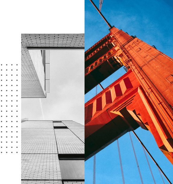 Black and white modern building contrasted with colorful bridge structure in blue sky.