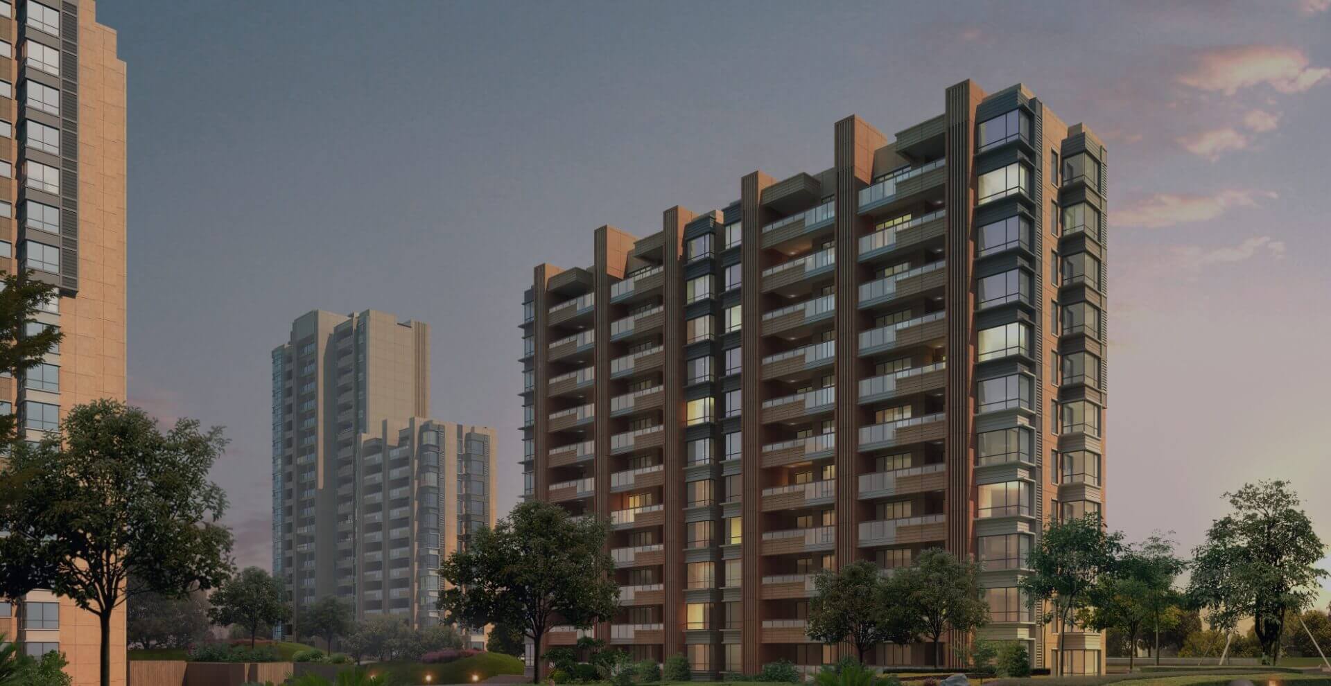Modern apartment buildings during sunset with landscaped greenery.