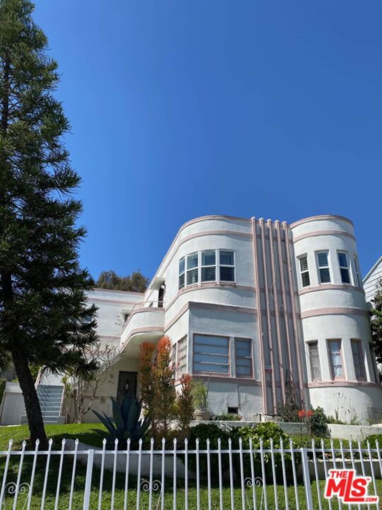 White art deco style building with curved windows under a clear blue sky.