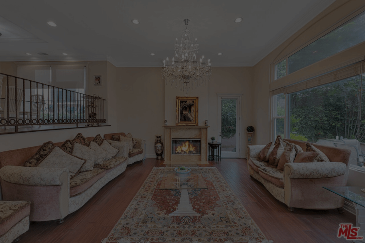 Elegant living room with two sofas, a fireplace, and a chandelier.