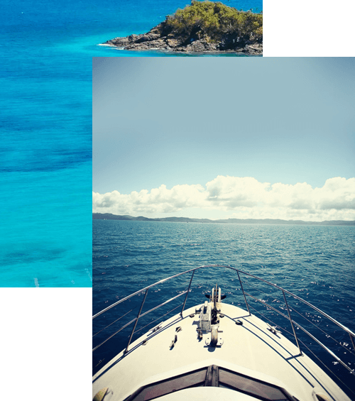 View from a boat sailing on a calm sea towards distant islands under a clear sky.