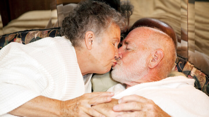 Elderly couple sharing a tender kiss.
