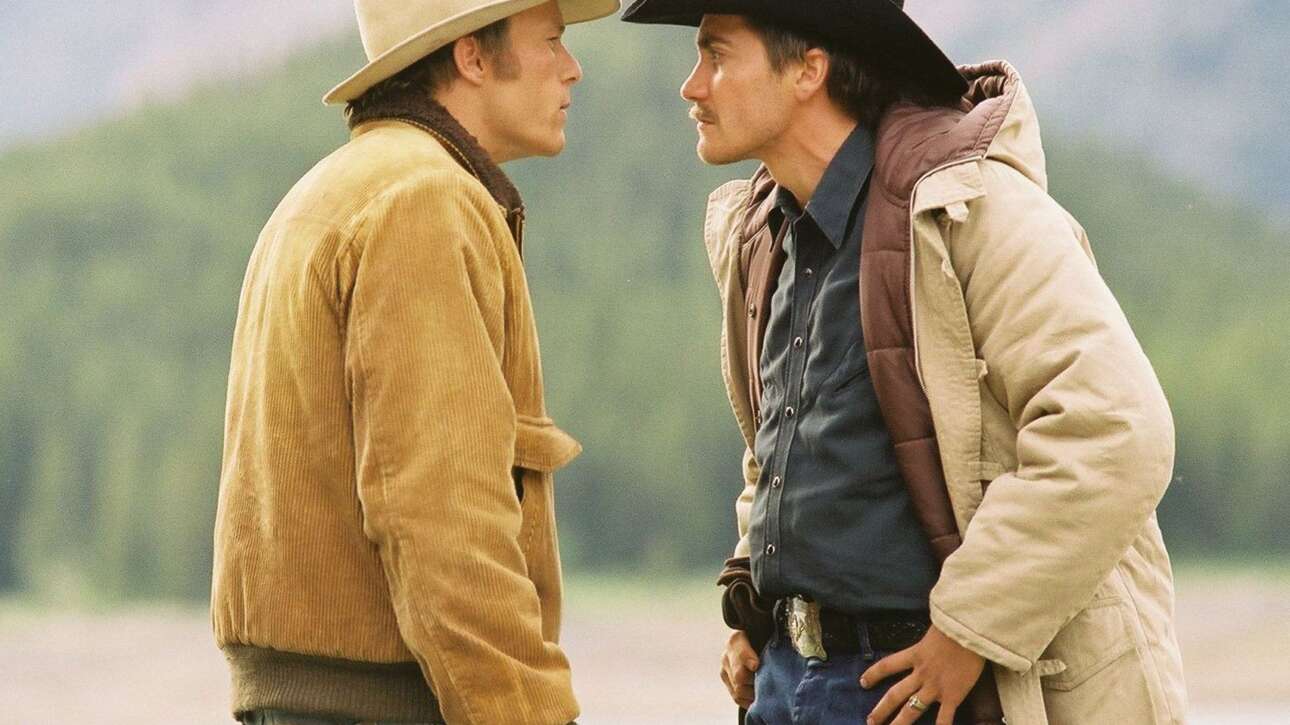 Two cowboys facing each other outdoors.