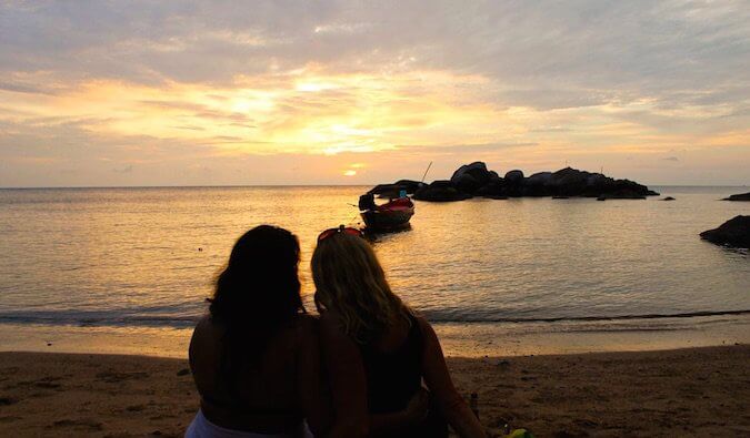 Couple watching sunset on a beach.