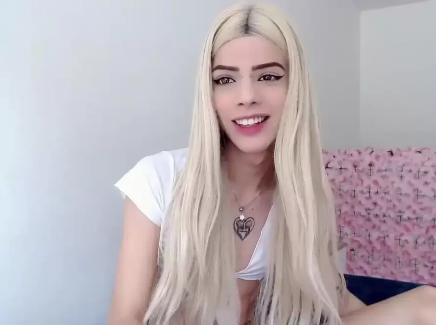 Person with long blonde hair smiling indoors.