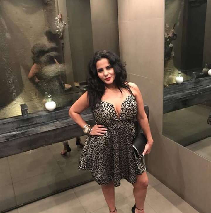 Woman in patterned dress posing in mirror.
