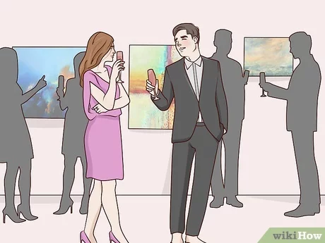 People chatting at an art gallery event.