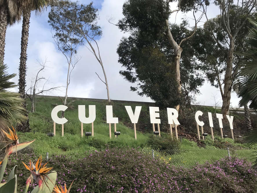 The iconic Culver City sign surrounded by greenery and flowers.