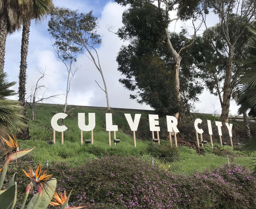 The iconic Culver City sign surrounded by greenery and flowers.