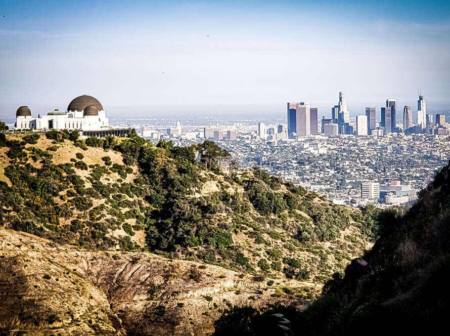 View of a city skyline from a hilltop with a clear sky.