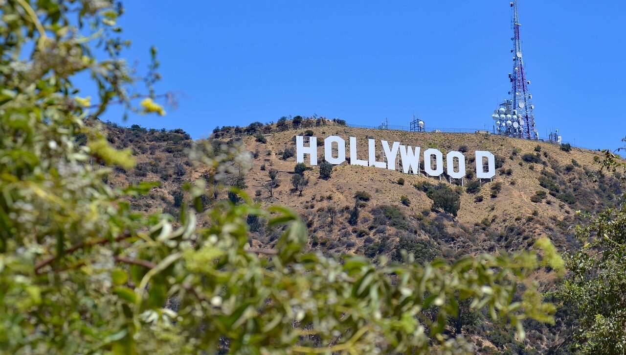 The iconic Hollywood sign on a hill with clear blue sky.