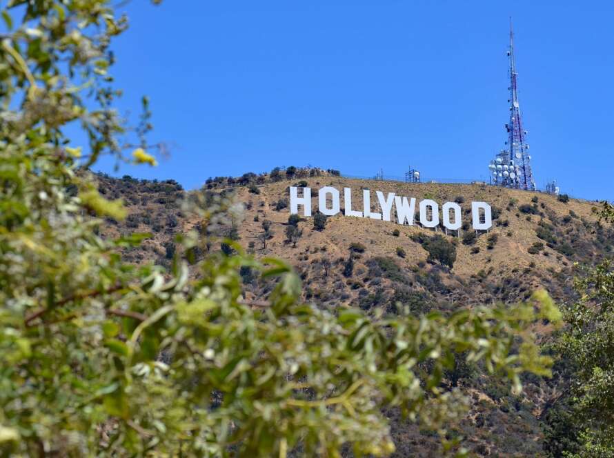 The iconic Hollywood sign on a hill with clear blue sky.